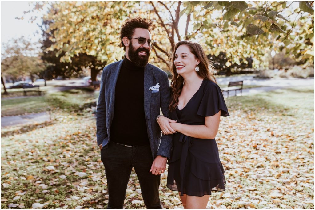 bride and groom walk through fallen leaves in DC