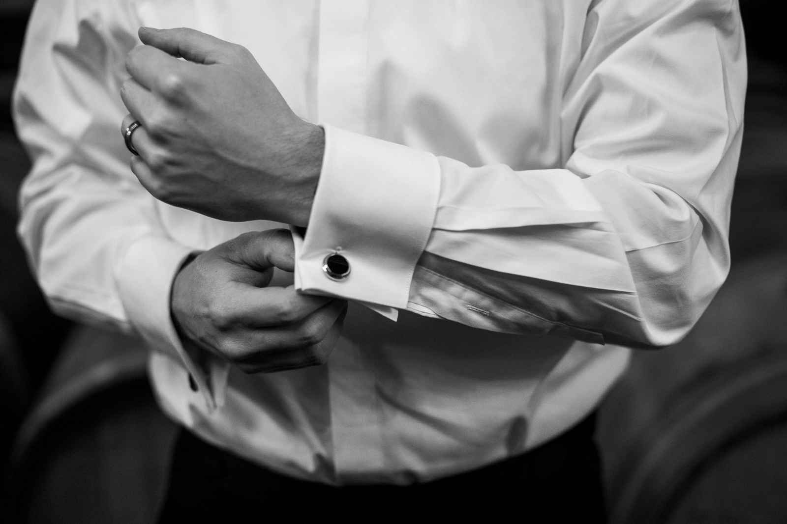 groom buttoning shirt at winery