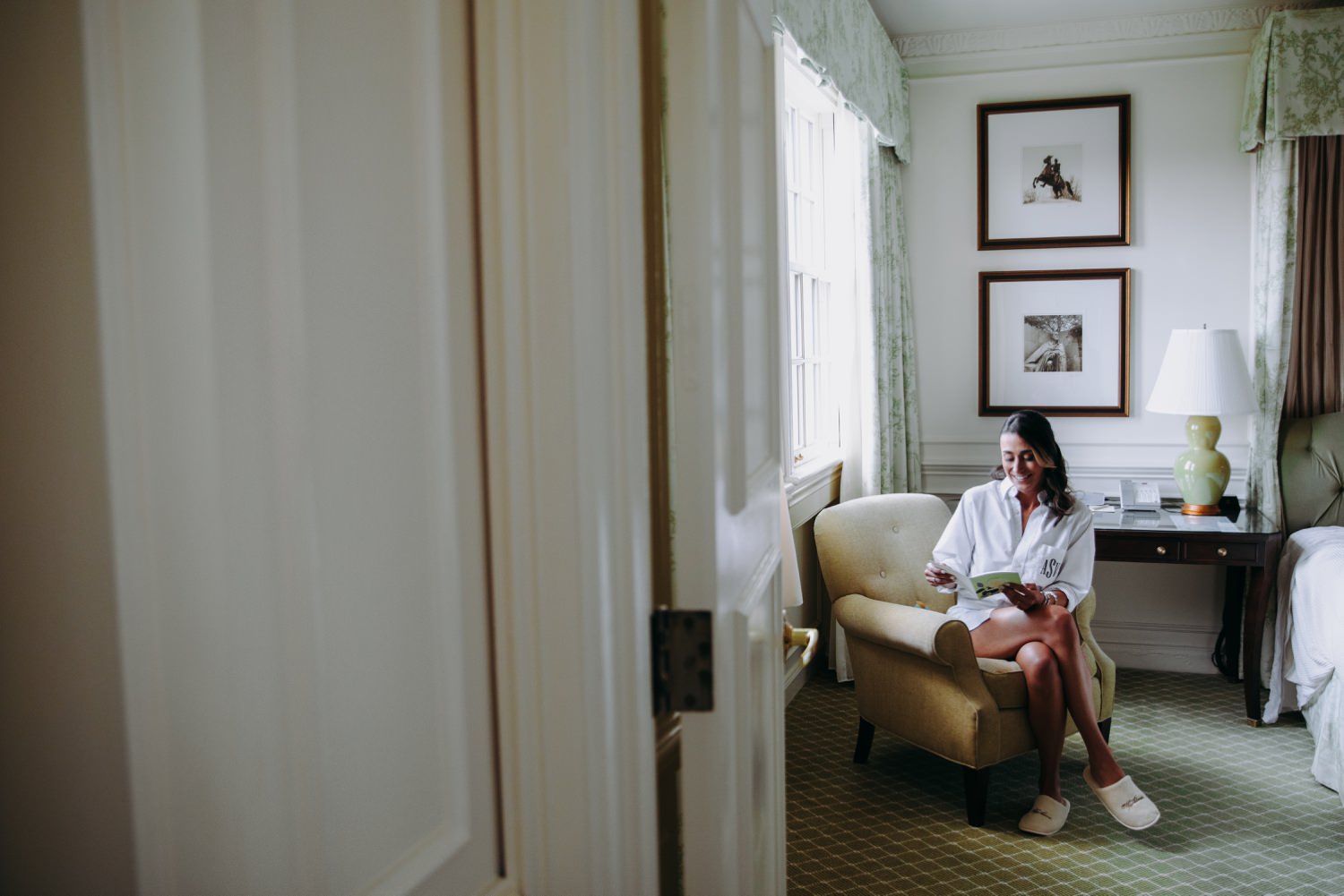 bride reading letter beside window