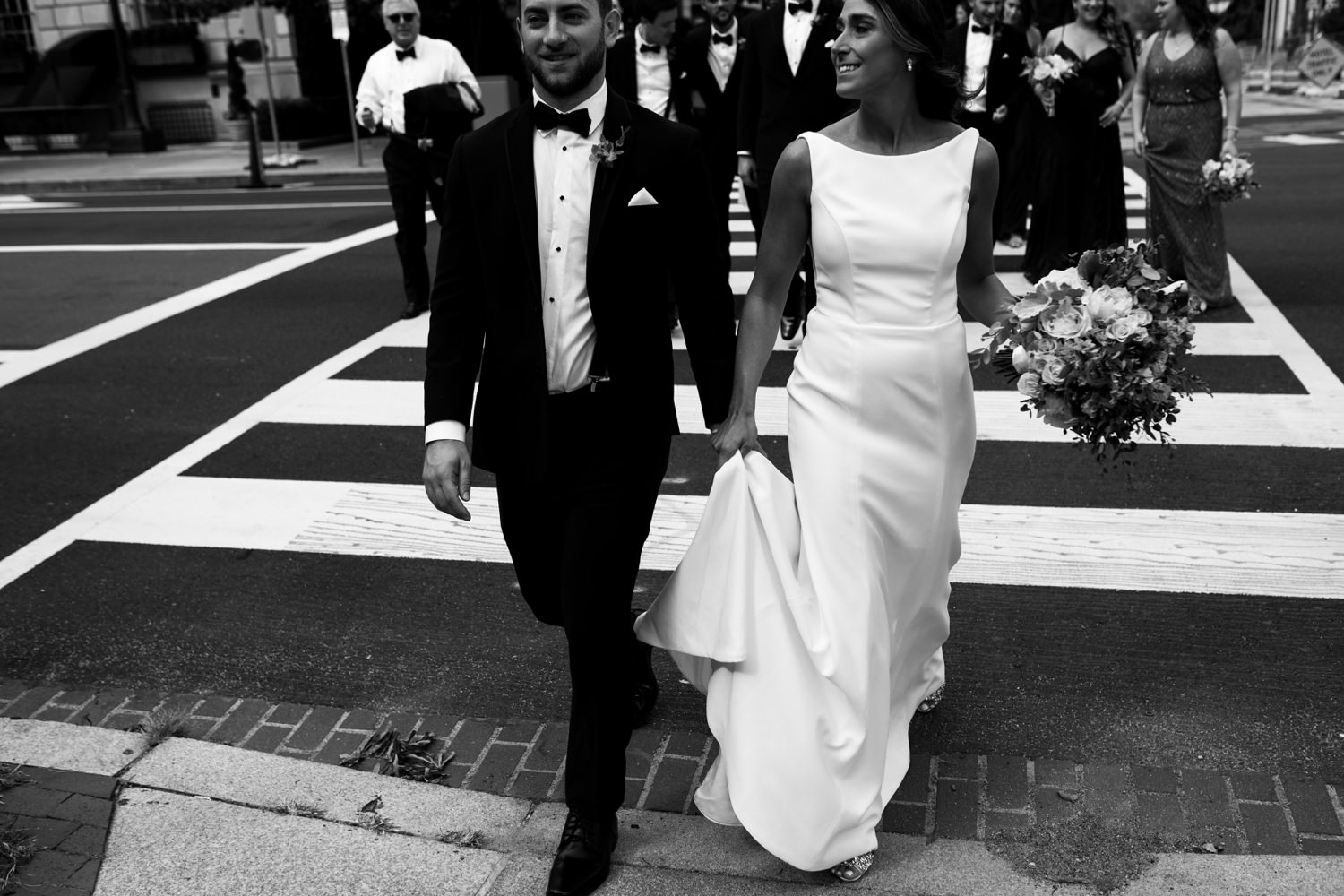 candid bride and groom walking on crosswalk