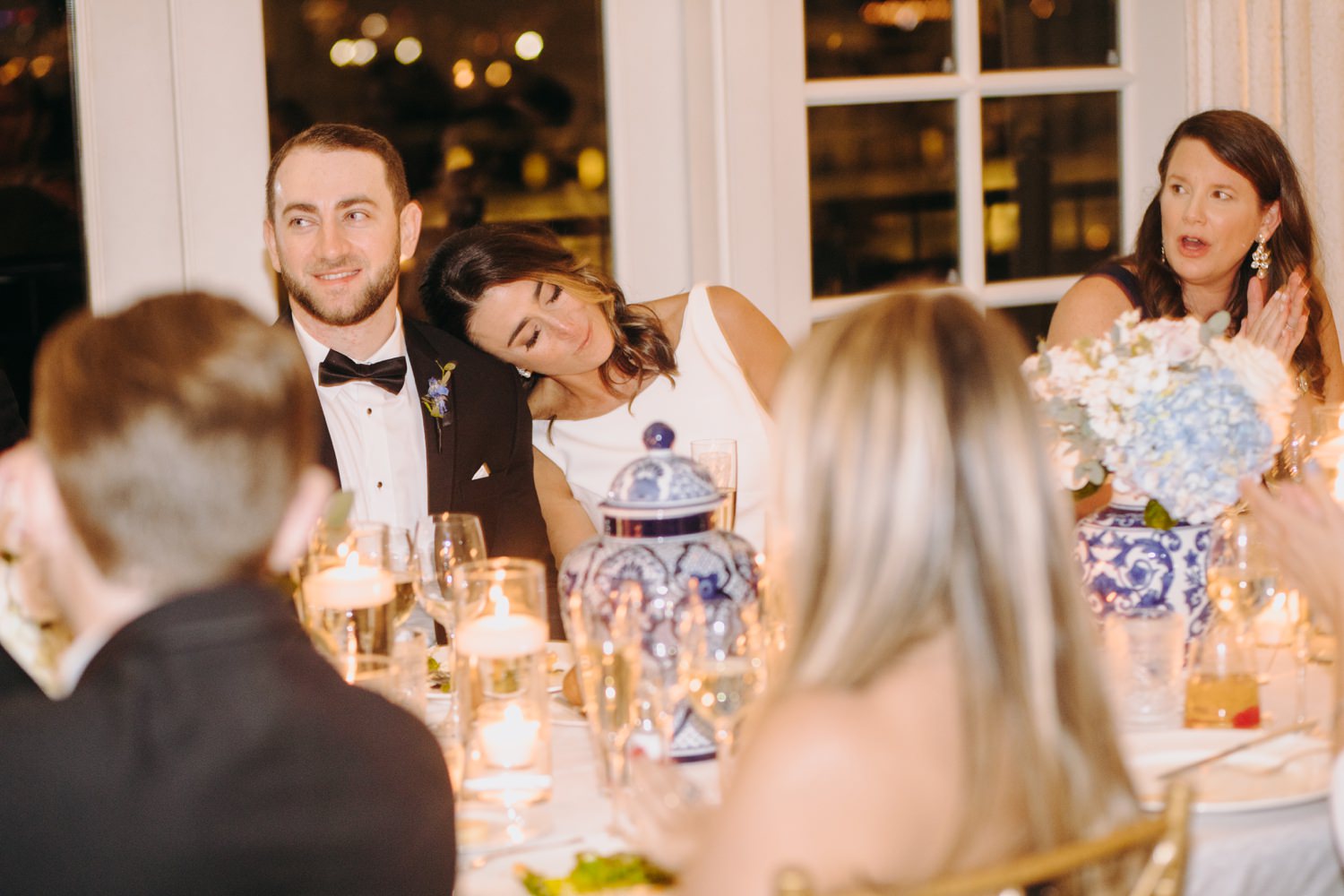 bride leans on groom at reception