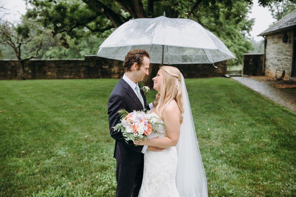 bride and groom under umbrella looking at each other