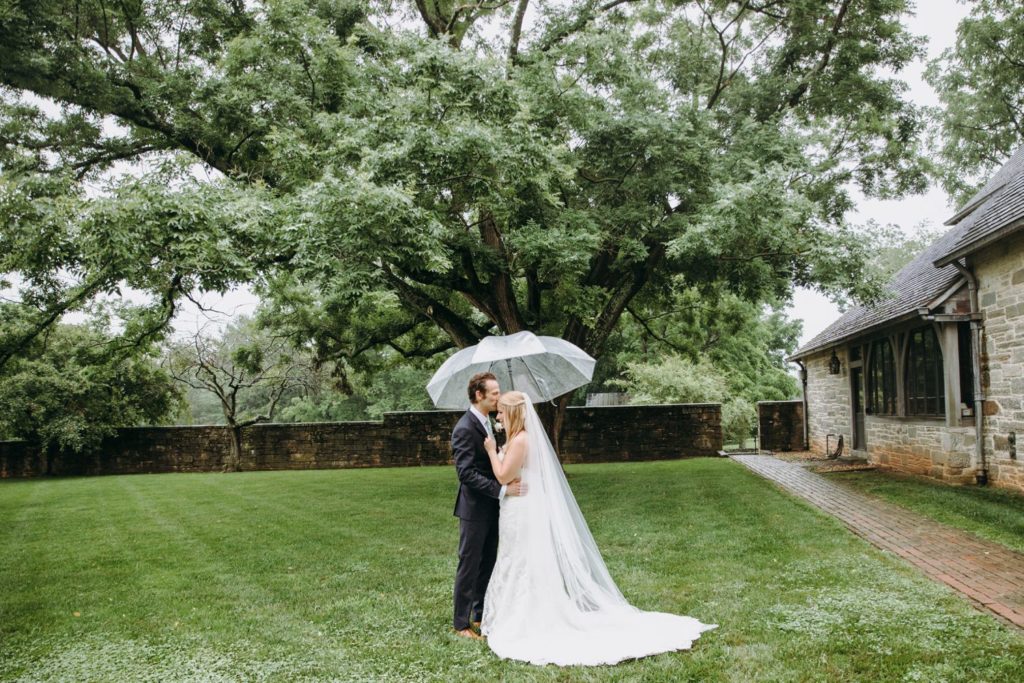 bride and groom under tree under umbrella