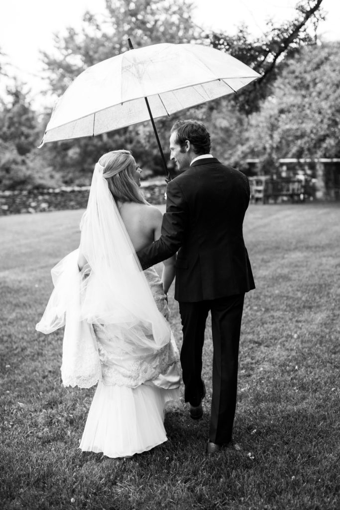 black and white bride and groom in rain