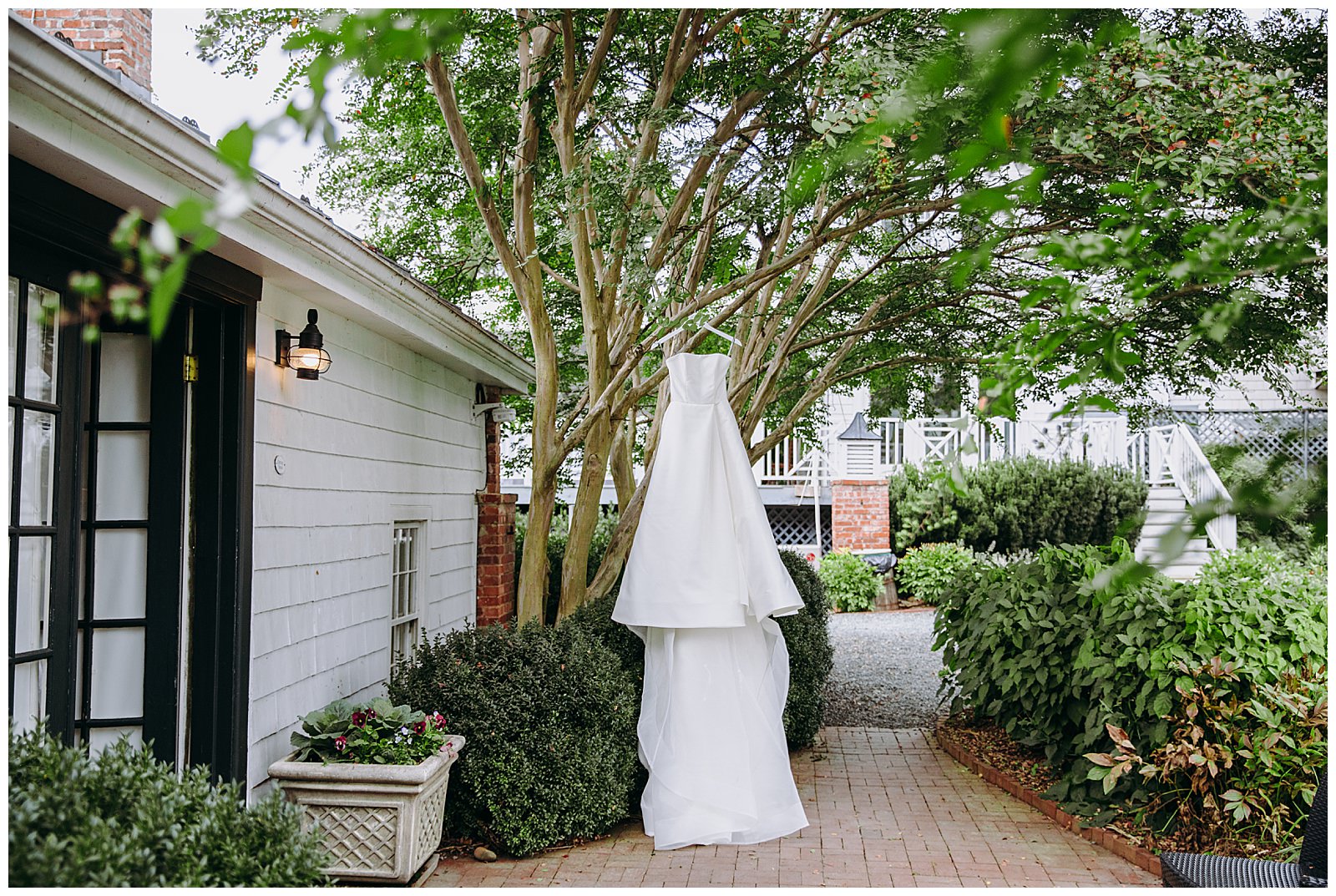 monique lhuillier wedding dress hanging from a tree