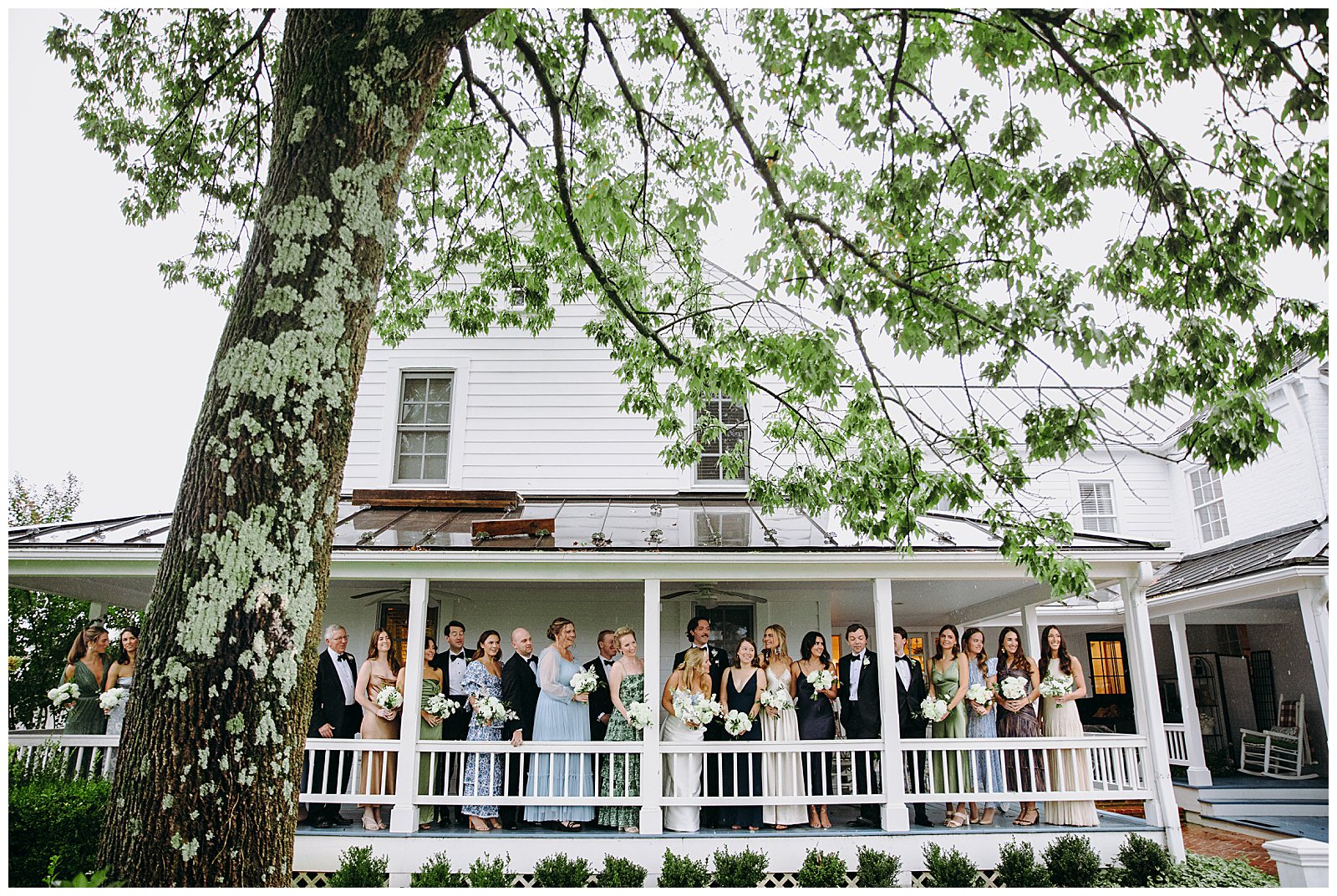 veritas wedding bridal party on porch during rain