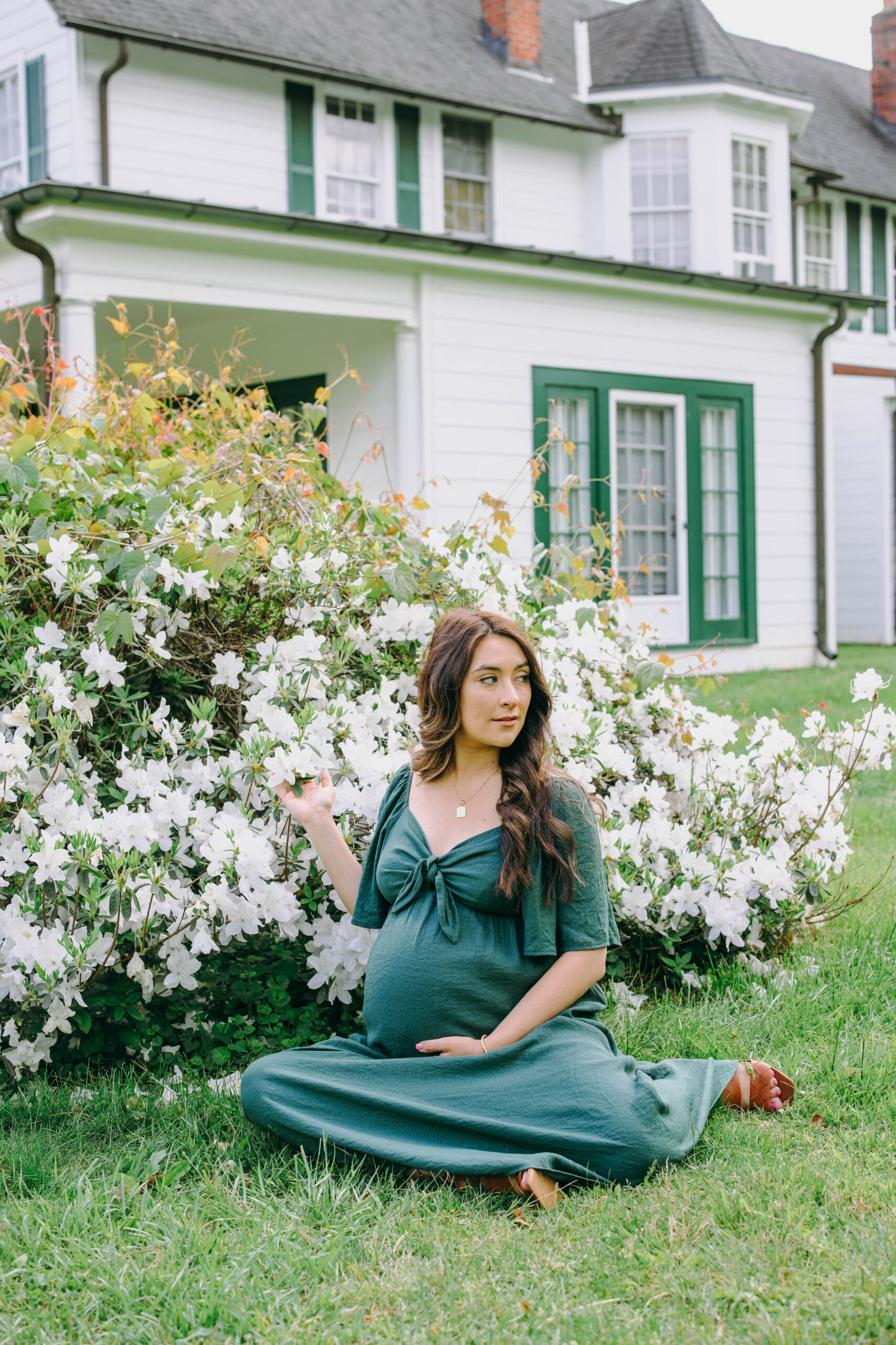 maternity photo of mother sitting in front of flowers