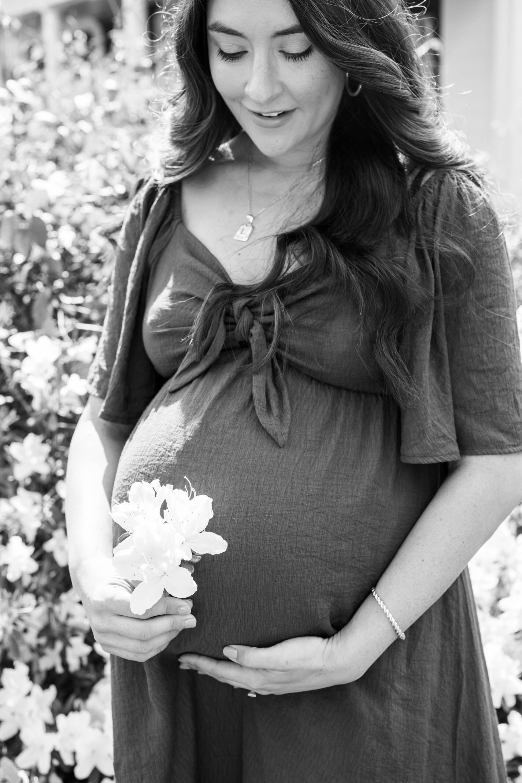 maternity photo of mother next to flowers in black and white