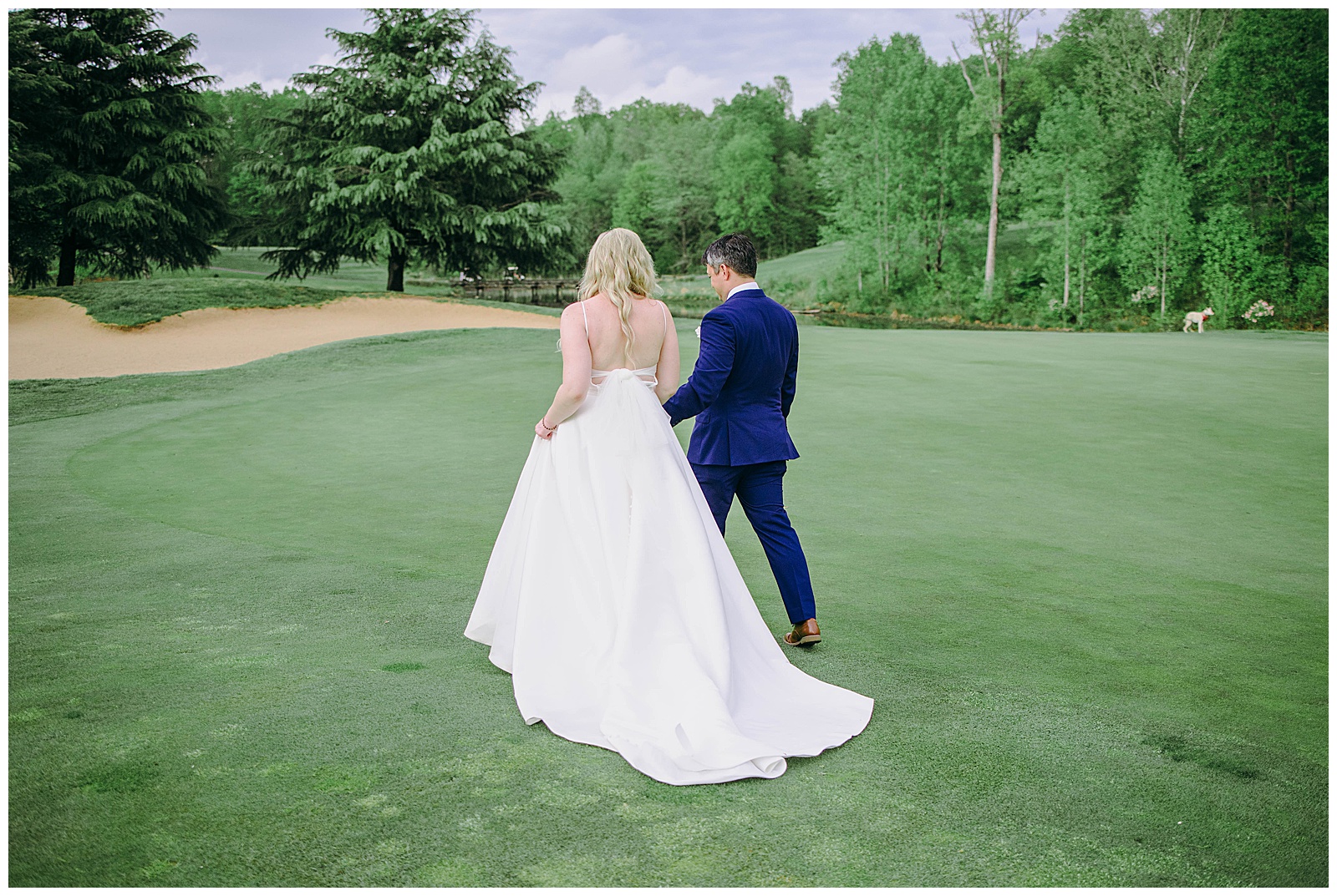 bride and groom walk away together on golf course