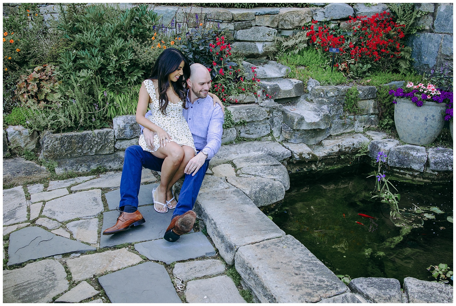 engaged couple sitting by water