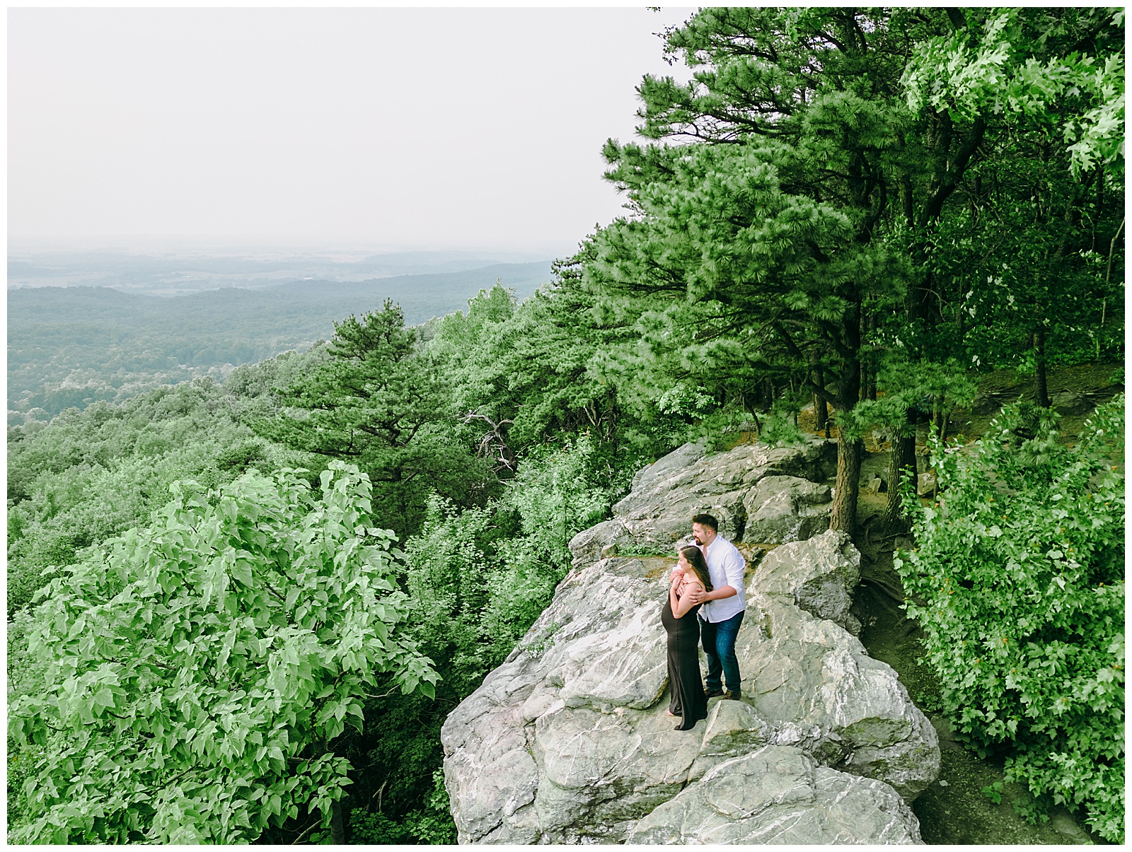couple looking out over the mountain on a rock at Maternity Photos at Bear's Den