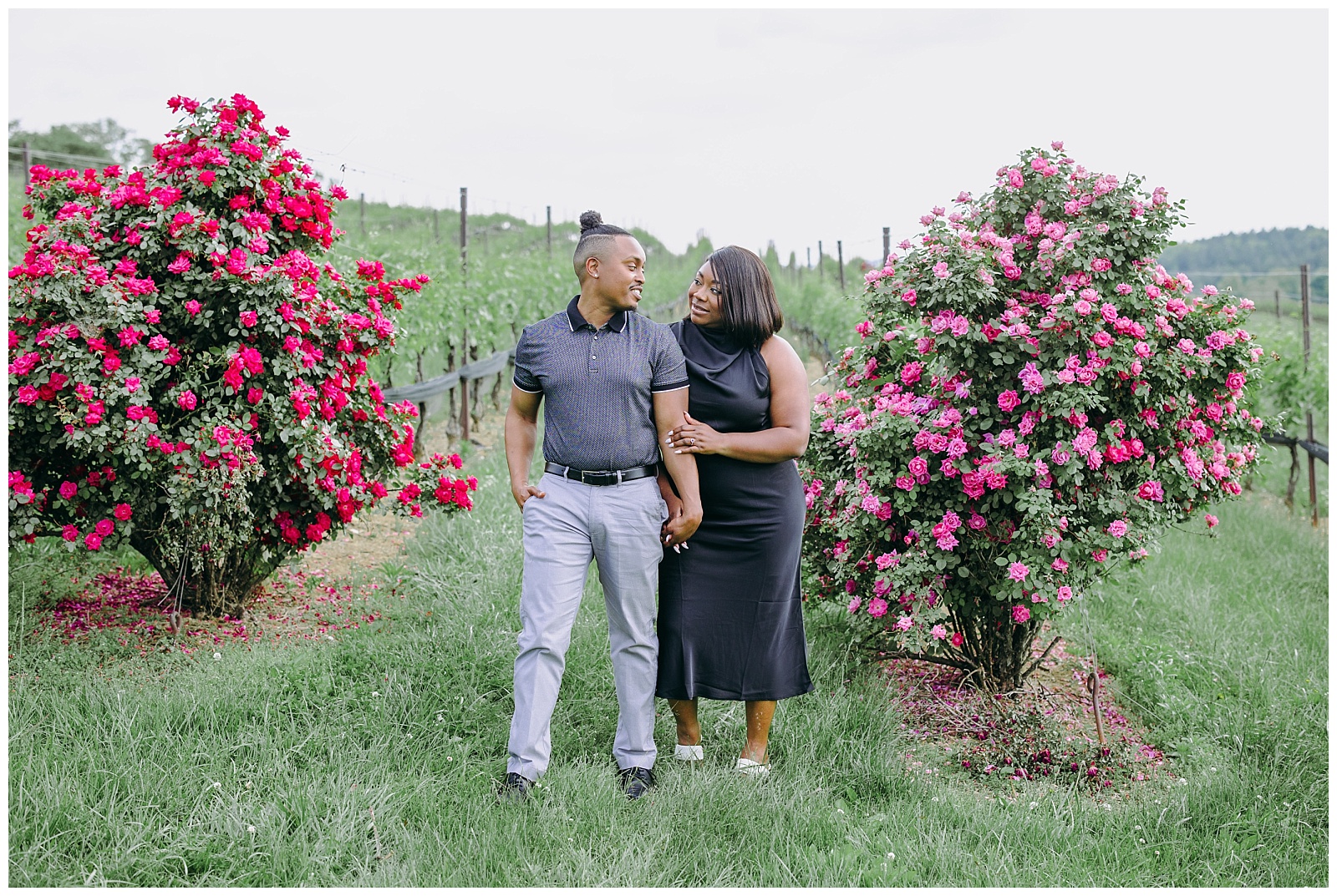 engaged couple in front of pink flowers
